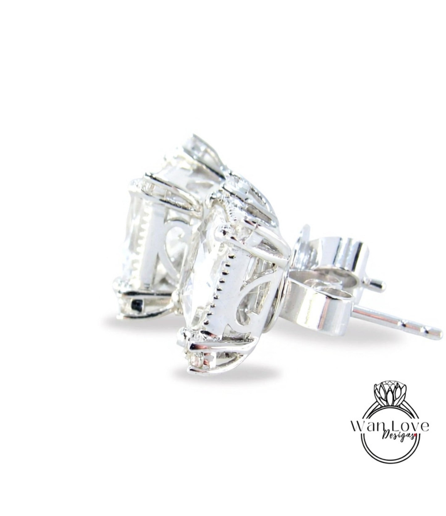 A pair of elegant silver earrings with a clear gemstone set in the center, resting on a white background.