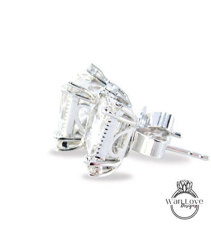 A pair of elegant silver earrings with a clear gemstone set in the center, resting on a white background.