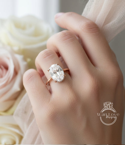 A close-up of a person's hand wearing a large oval-shaped diamond engagement ring.