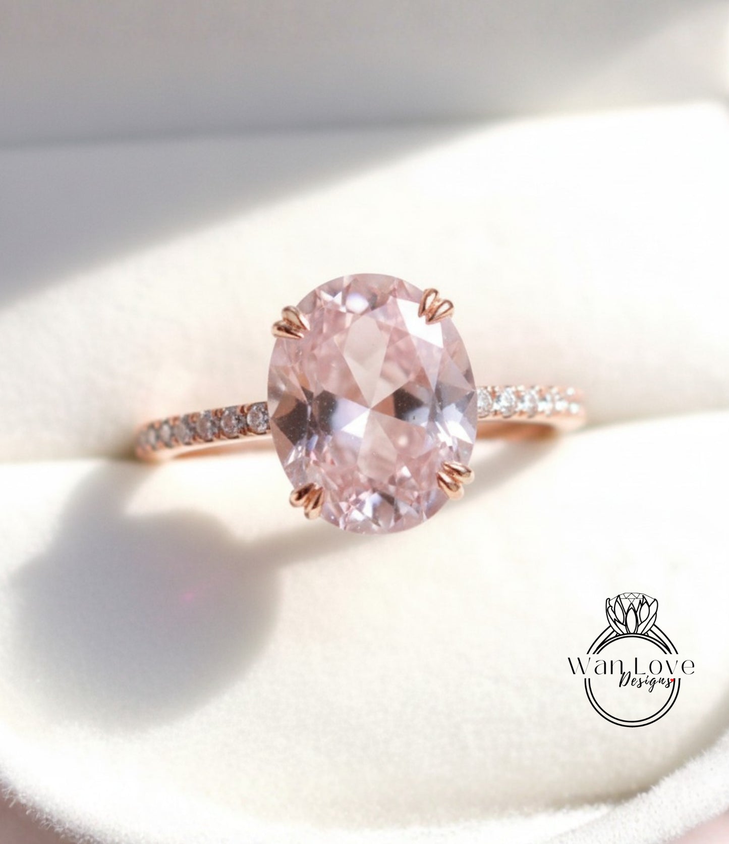 A close-up image of a pink gemstone ring with a large oval-shaped gemstone set in a rose gold band.