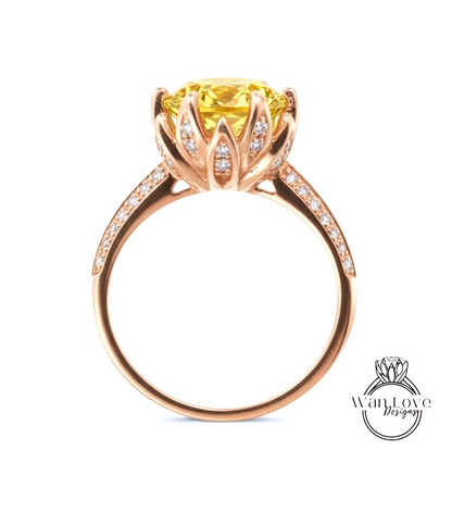 A gold ring with a large yellow gemstone, possibly a diamond, set in a flower-like design.