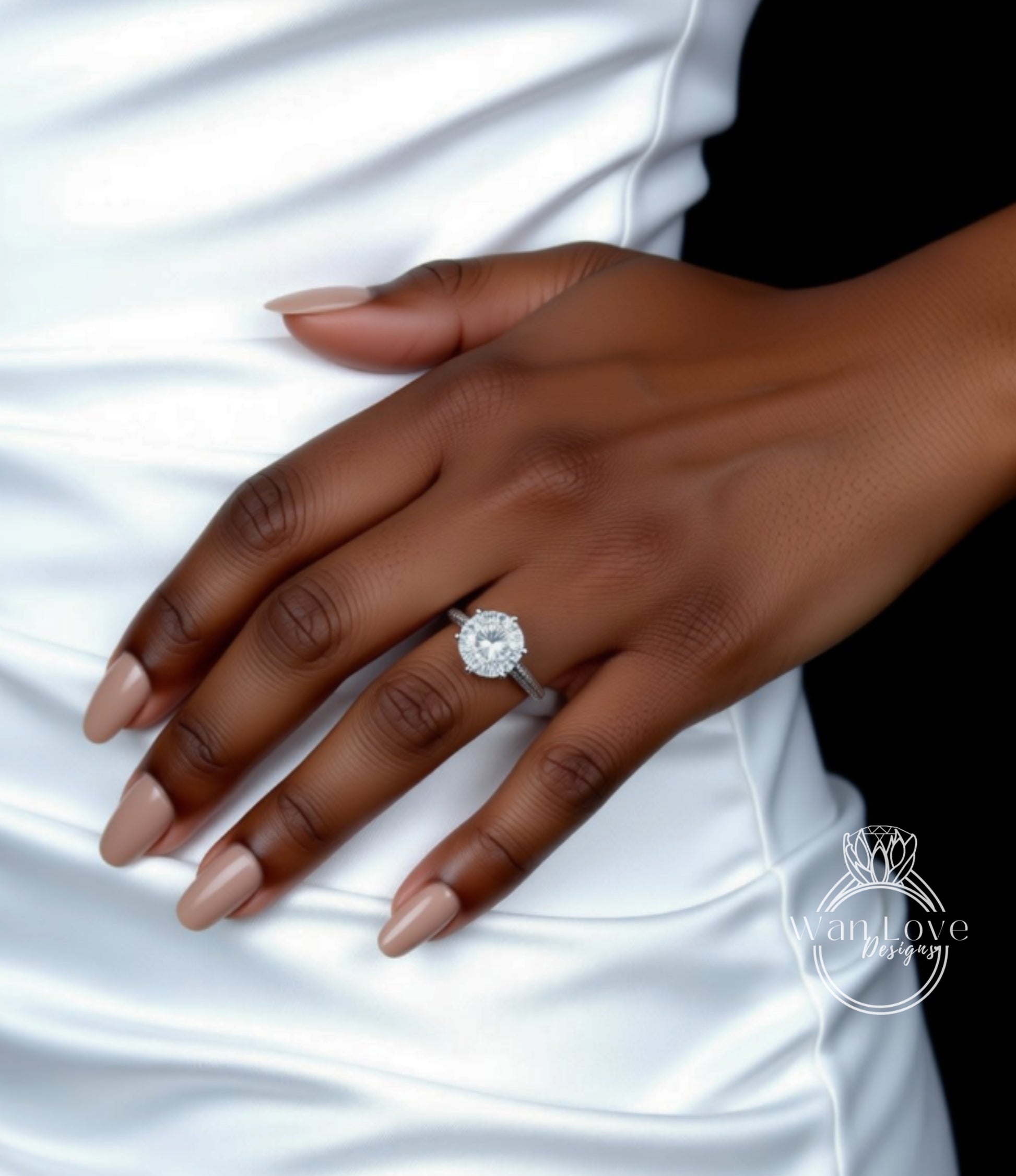 A close-up of a hand wearing a diamond engagement ring, with a white dress visible in the background.