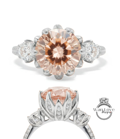 a beautiful engagement ring with a large, round, peach-colored gemstone set in a silver band. The ring is adorned with smaller diamonds and has a delicate floral design around the center stone.