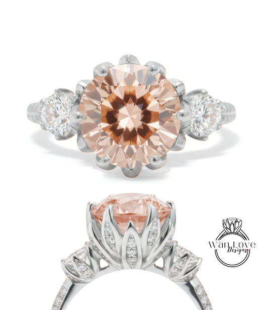 a beautiful engagement ring with a large, round, peach-colored gemstone set in a silver band. The ring is adorned with smaller diamonds and has a delicate floral design around the center stone.