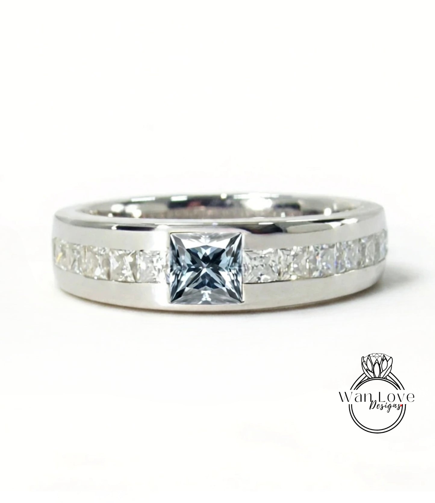 A silver ring with a large diamond in the center, surrounded by smaller diamonds along the band.