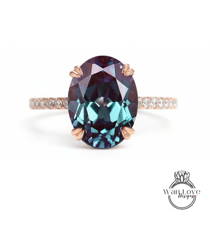 A large oval-shaped gemstone ring with a rose gold band and a small diamond accent.