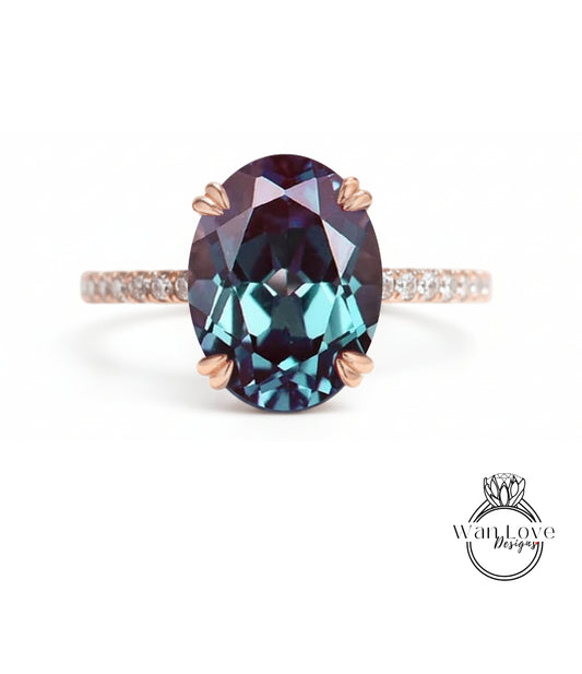 A large oval-shaped gemstone ring with a rose gold band and a small diamond accent.
