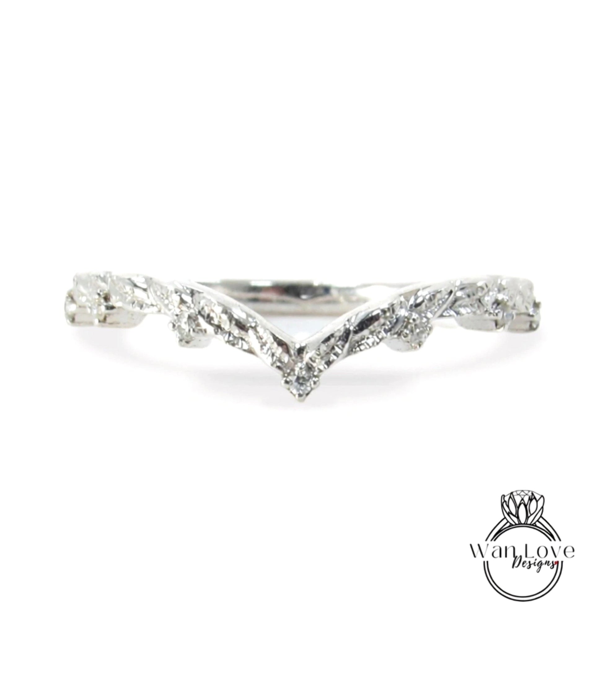 A silver ring with a leaf-like design on the band.