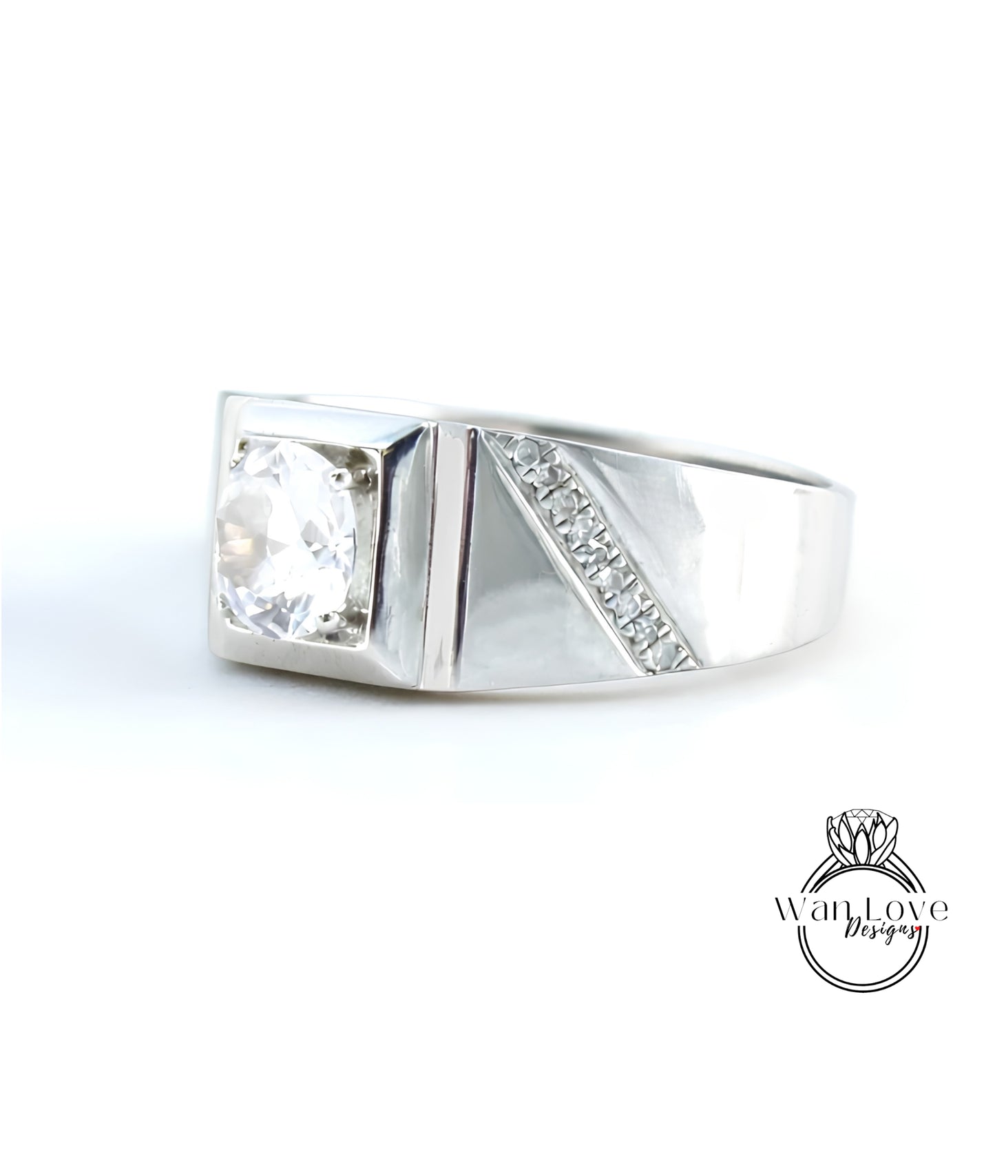 A silver ring with a large diamond set in the center, showcasing a unique design with a diagonal cut and a row of small diamonds along the side.