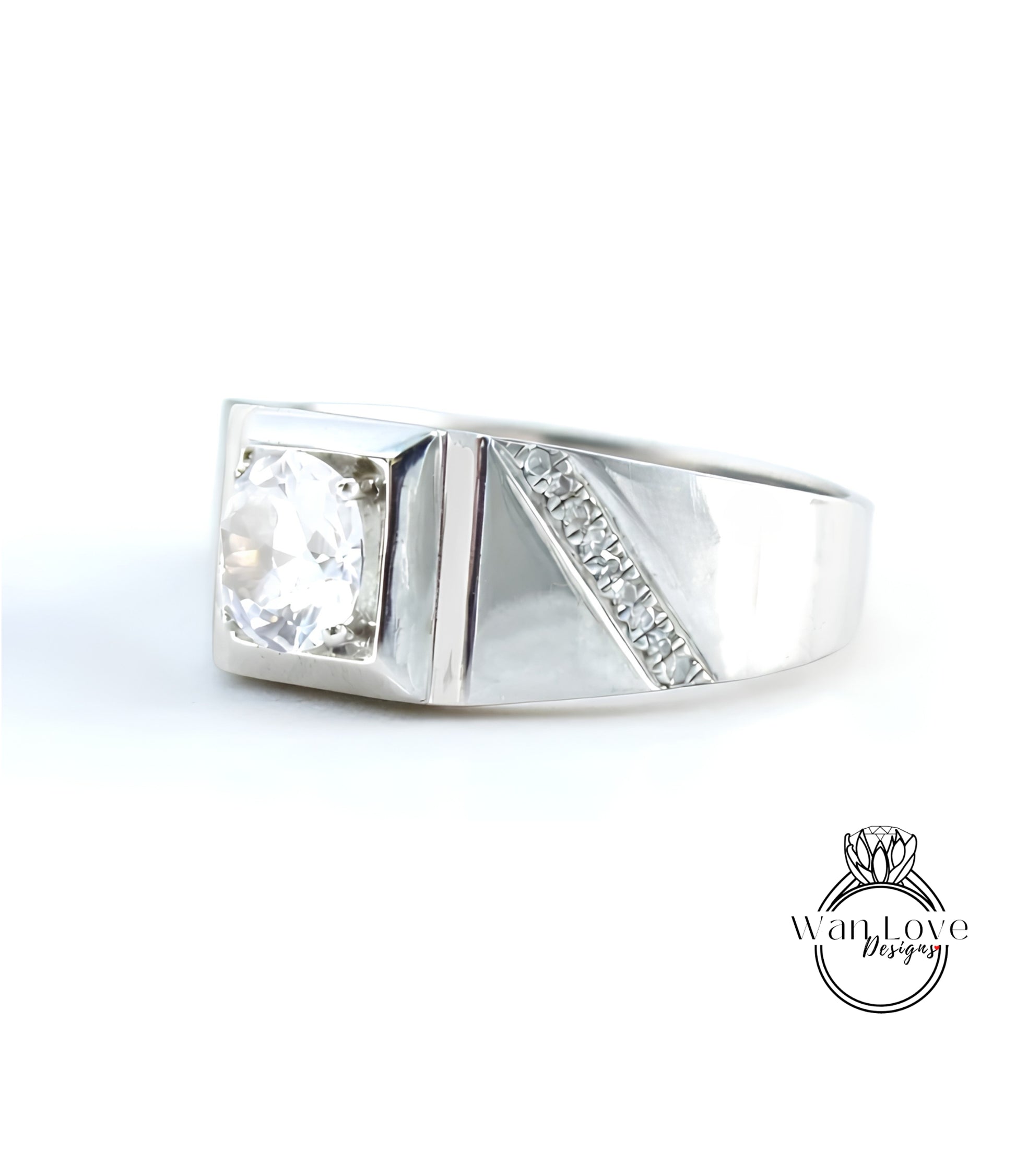 A silver ring with a large diamond set in the center, showcasing a unique design with a diagonal cut and a row of small diamonds along the side.