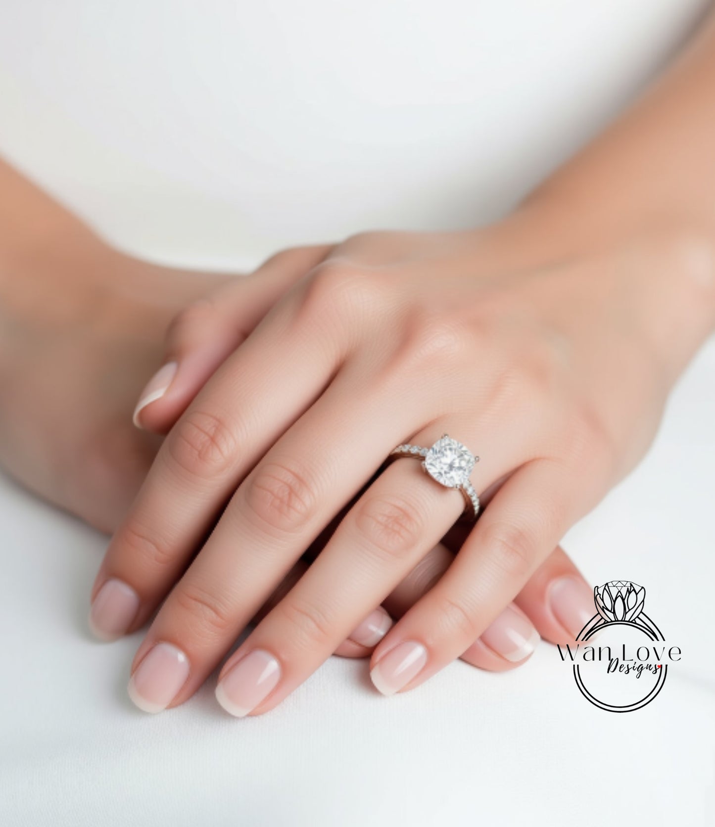 A close-up of a person's hand wearing a diamond engagement ring.