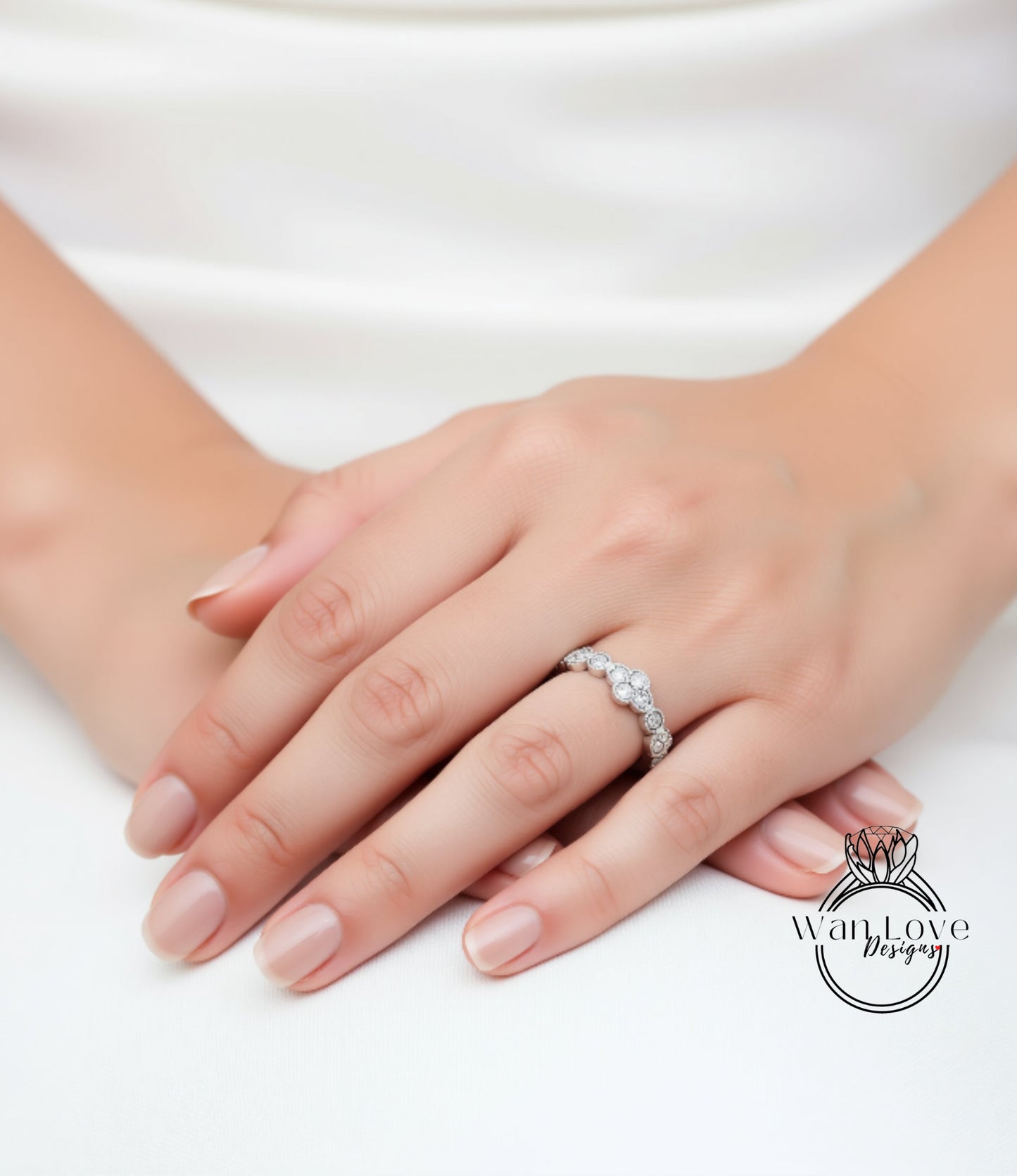 A close-up of a person's hand wearing a diamond engagement ring.