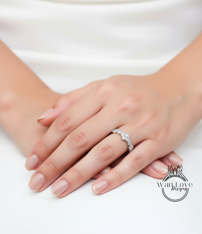 A close-up of a person's hand wearing a diamond engagement ring.