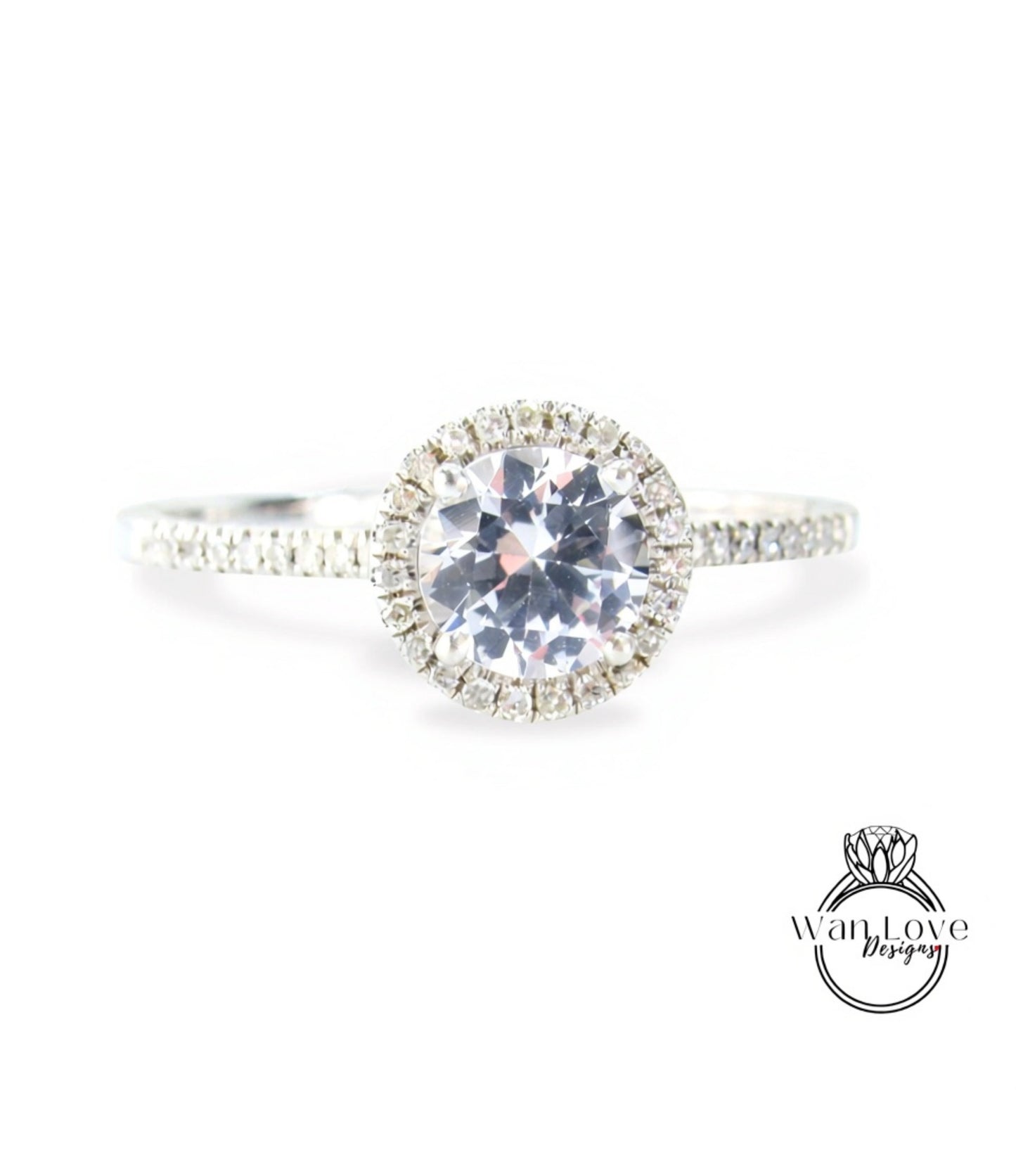 A close-up view of a diamond engagement ring with a large central diamond surrounded by smaller diamonds, set in a halo of smaller diamonds.