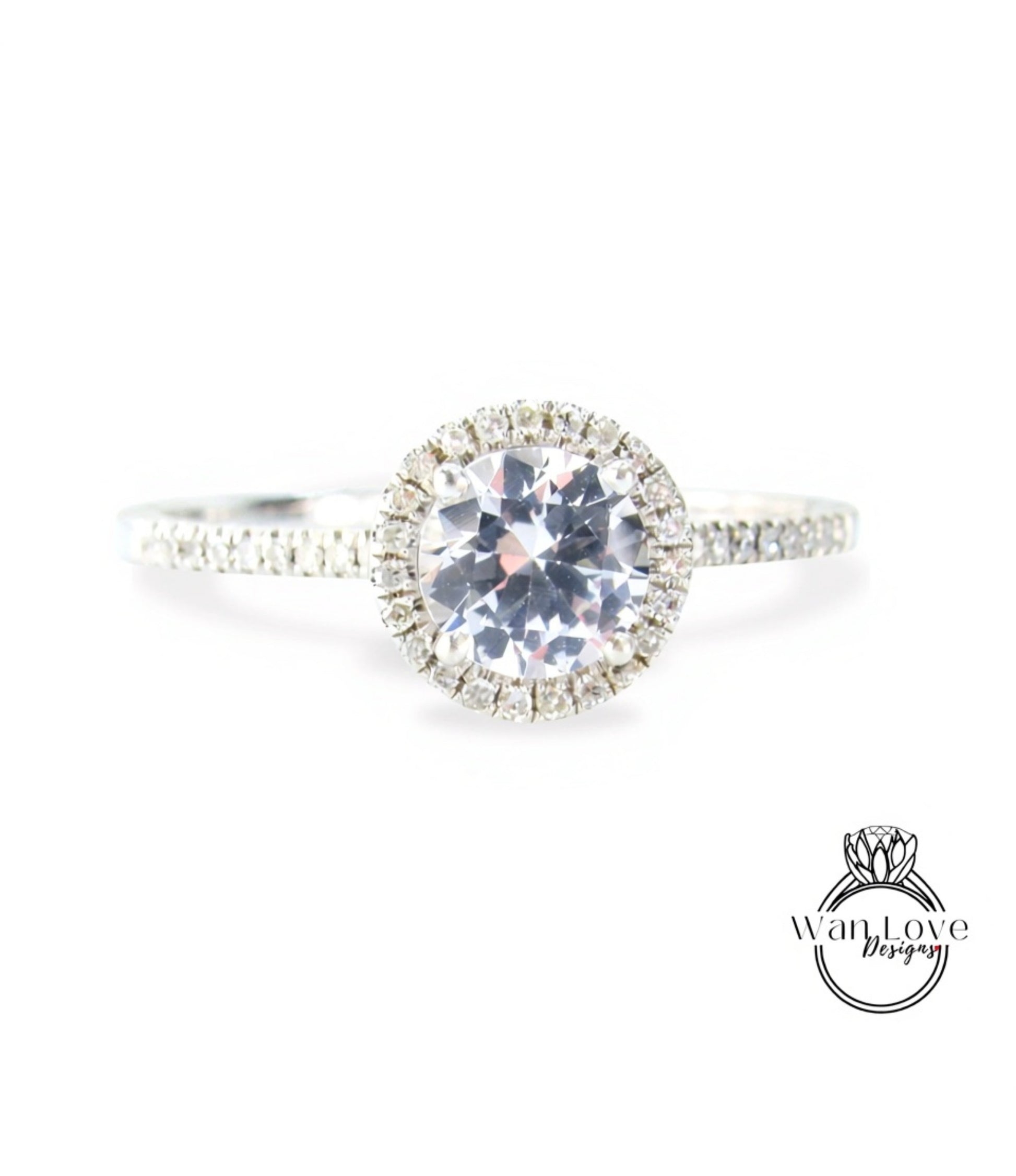 A close-up view of a diamond engagement ring with a large central diamond surrounded by smaller diamonds, set in a halo of smaller diamonds.