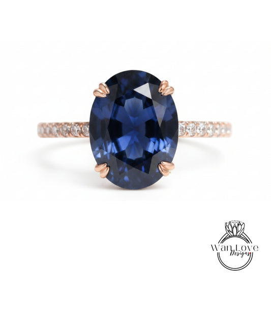 A close-up image of a blue gemstone ring with a large oval-shaped blue gemstone set in a rose gold band.