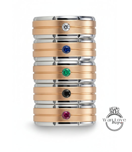 A stack of rings with various colored gemstones set in them, including a diamond ring at the top.
