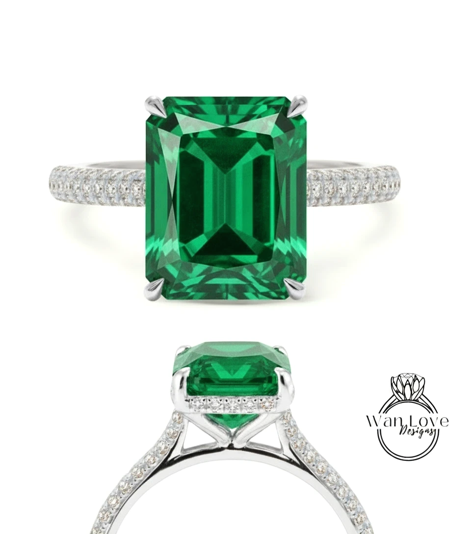 A stunning green gemstone engagement ring with a large central gemstone surrounded by smaller diamonds set in a silver band.