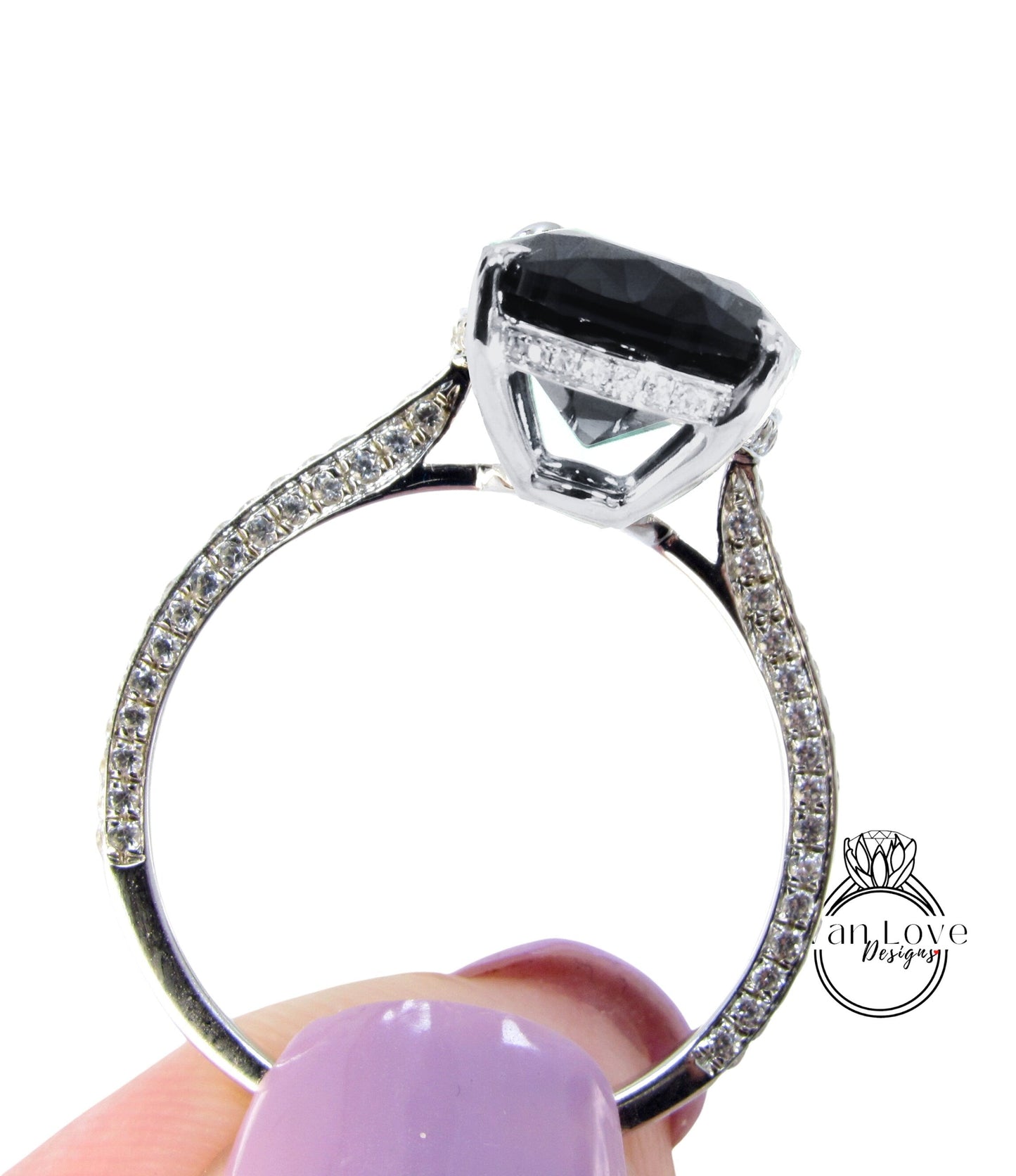 A close-up of a silver ring with a large black gemstone, possibly a diamond, set in the center.