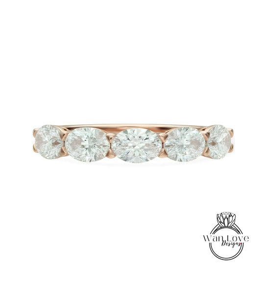 a beautiful rose gold ring with a row of five oval-shaped diamonds set in the band.
