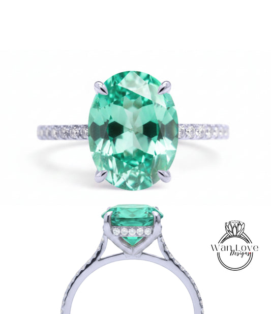 A stunning engagement ring with a large oval-shaped gemstone set in a silver band, surrounded by smaller diamonds.