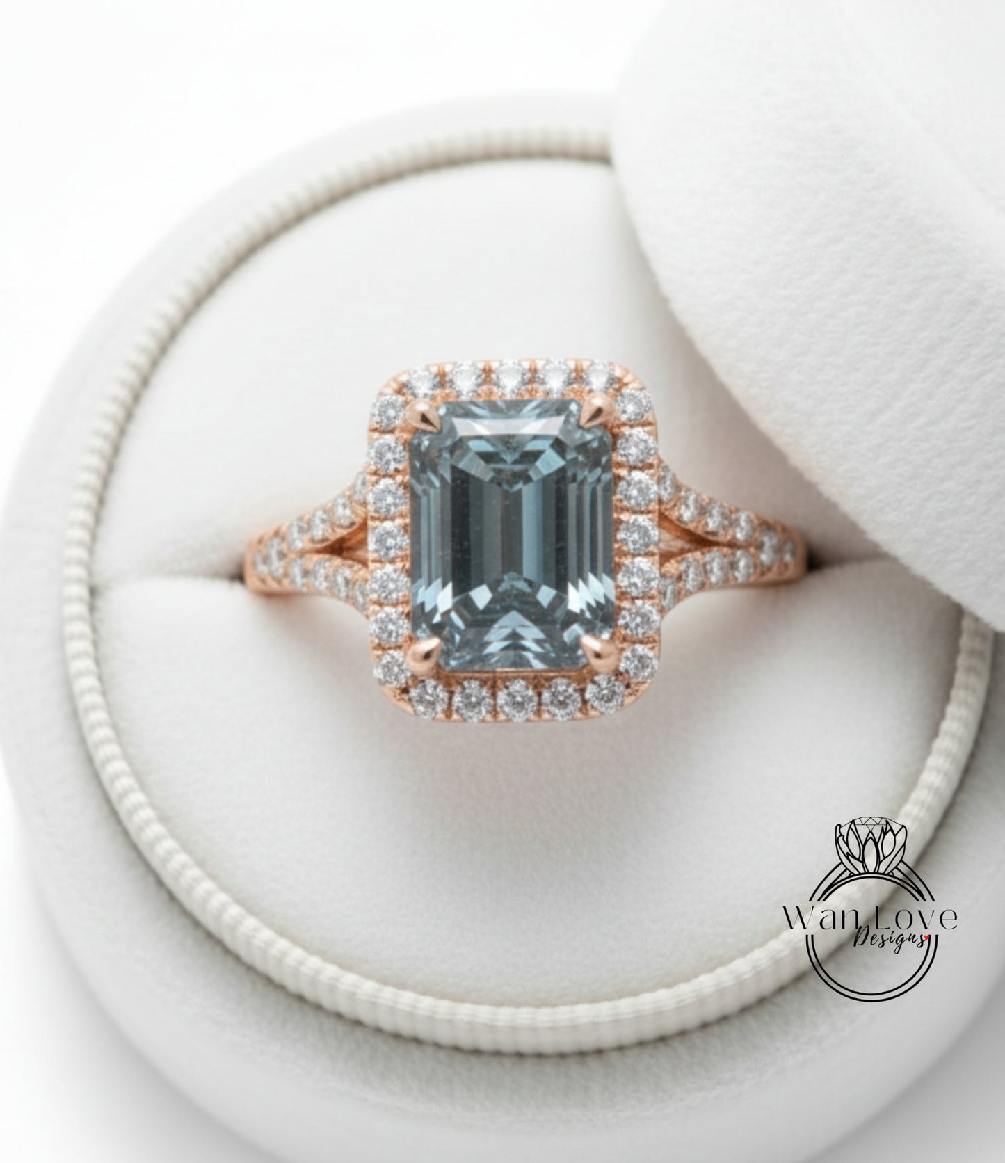 A beautiful engagement ring with a large blue gemstone set in a halo of smaller diamonds, displayed in a white jewelry box.
