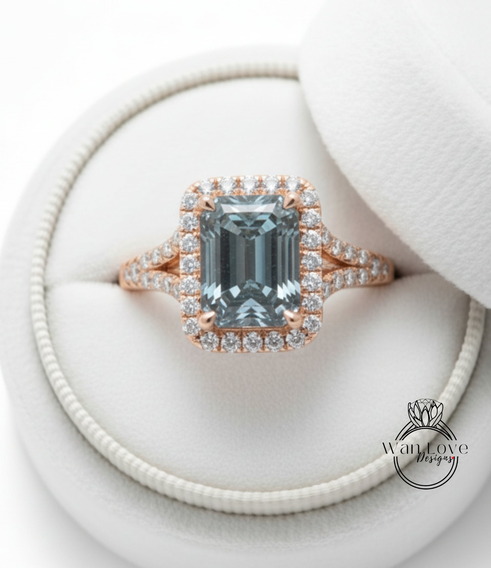 A beautiful engagement ring with a large blue gemstone set in a halo of smaller diamonds, displayed in a white jewelry box.