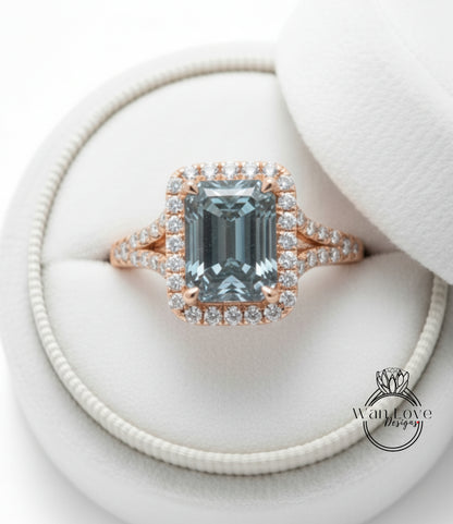 A beautiful engagement ring with a large blue gemstone set in a halo of smaller diamonds, displayed in a white jewelry box.