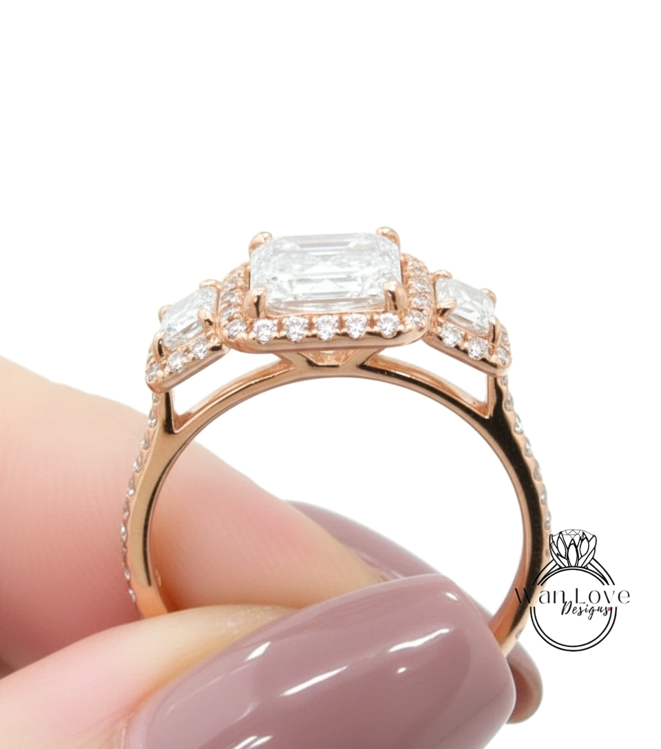 A close-up of a person's hand holding a gold ring with a large diamond in the center, surrounded by smaller diamonds.