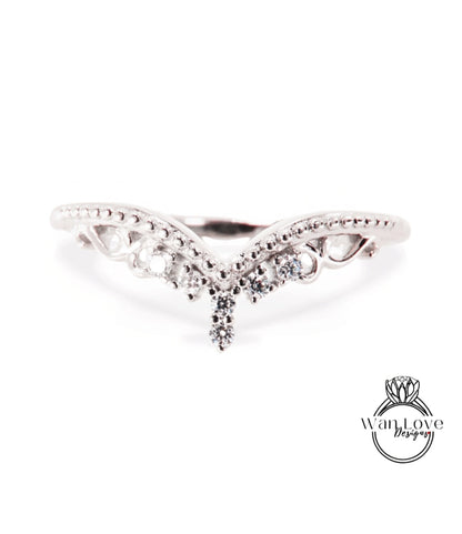 A silver ring with a decorative band featuring a central diamond and smaller diamonds surrounding it.