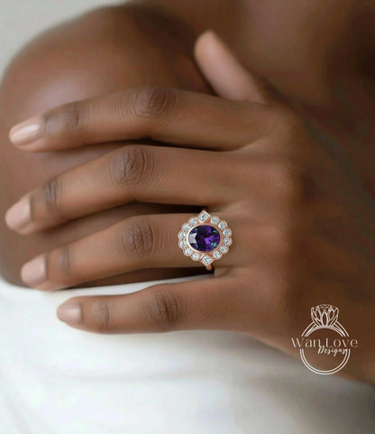 A close-up of a hand wearing a ring with a large purple gemstone.