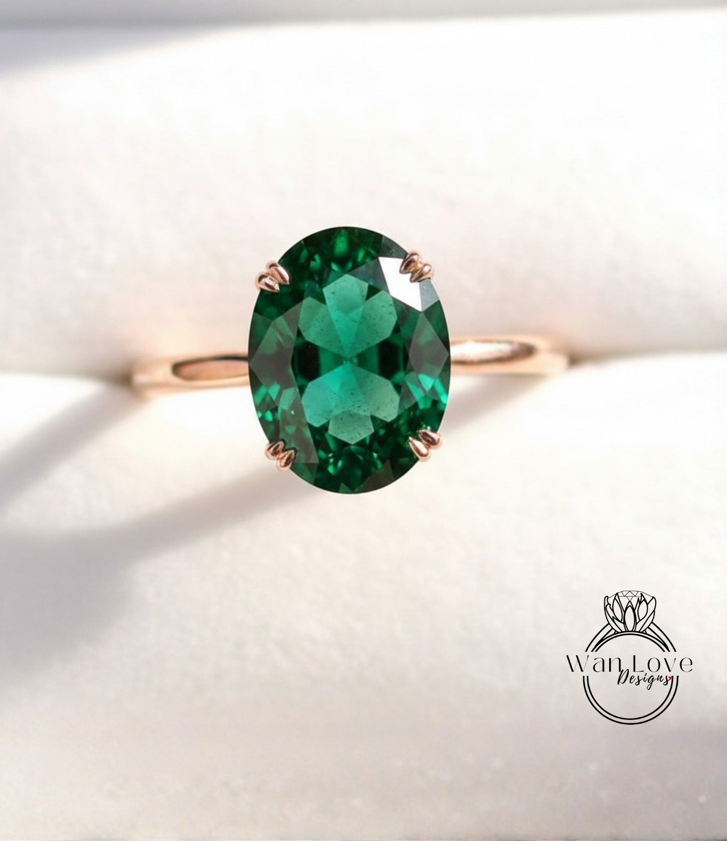 A gold ring with a large oval-shaped green gemstone, which appears to be a diamond.