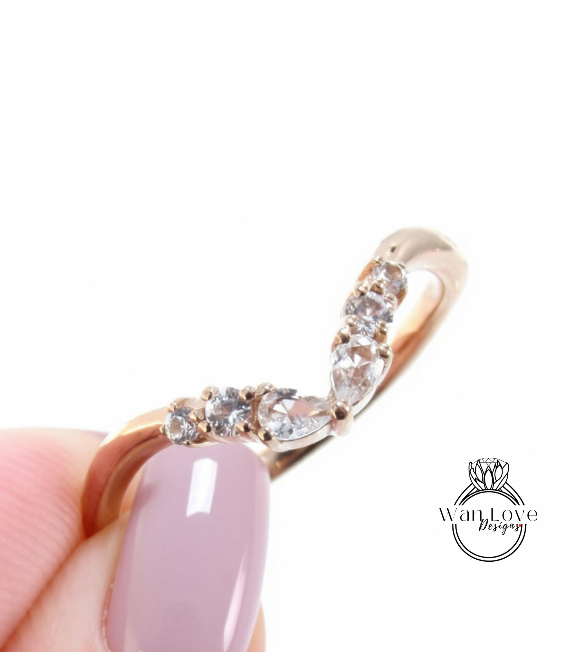 A close-up of a person's hand holding a gold ring with a diamond-encrusted band.