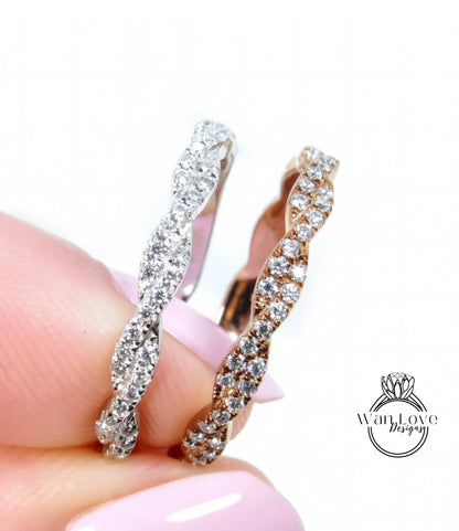 A close-up of a person's hand holding a silver and gold ring with sparkling diamonds.