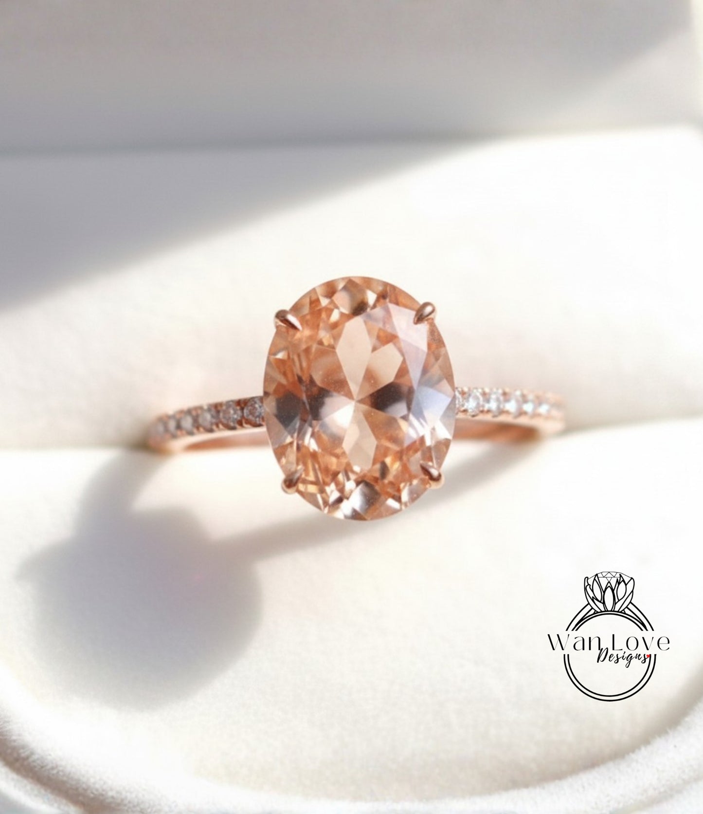 A close-up image of a rose gold engagement ring with a large oval-shaped gemstone set in the center.