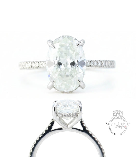 A close-up view of a diamond engagement ring with a large oval-shaped diamond set in a halo of smaller diamonds, surrounded by a band of smaller diamonds.