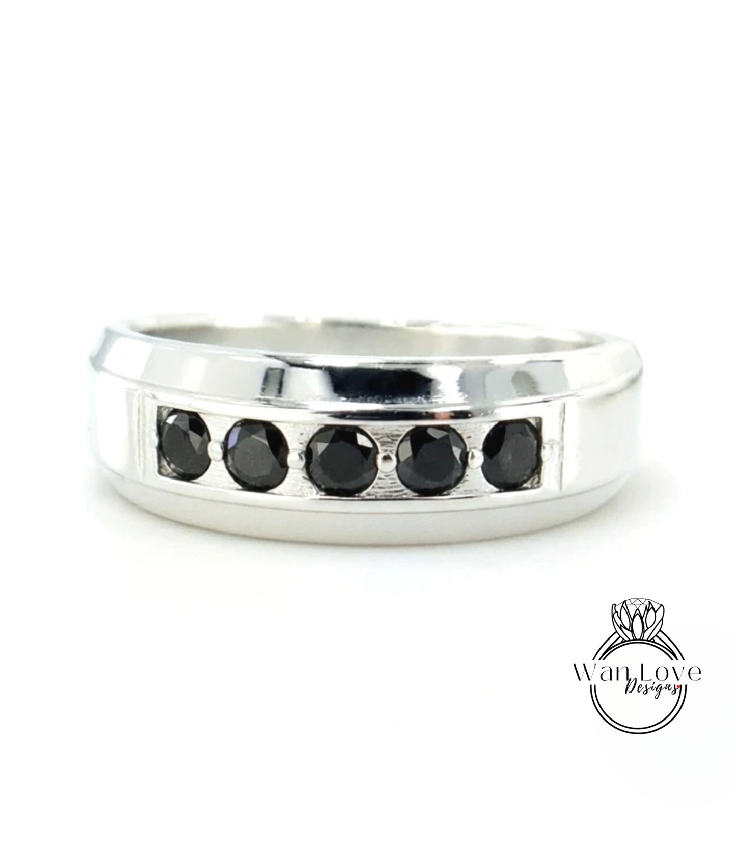 A silver ring with a row of black diamonds set in the band.