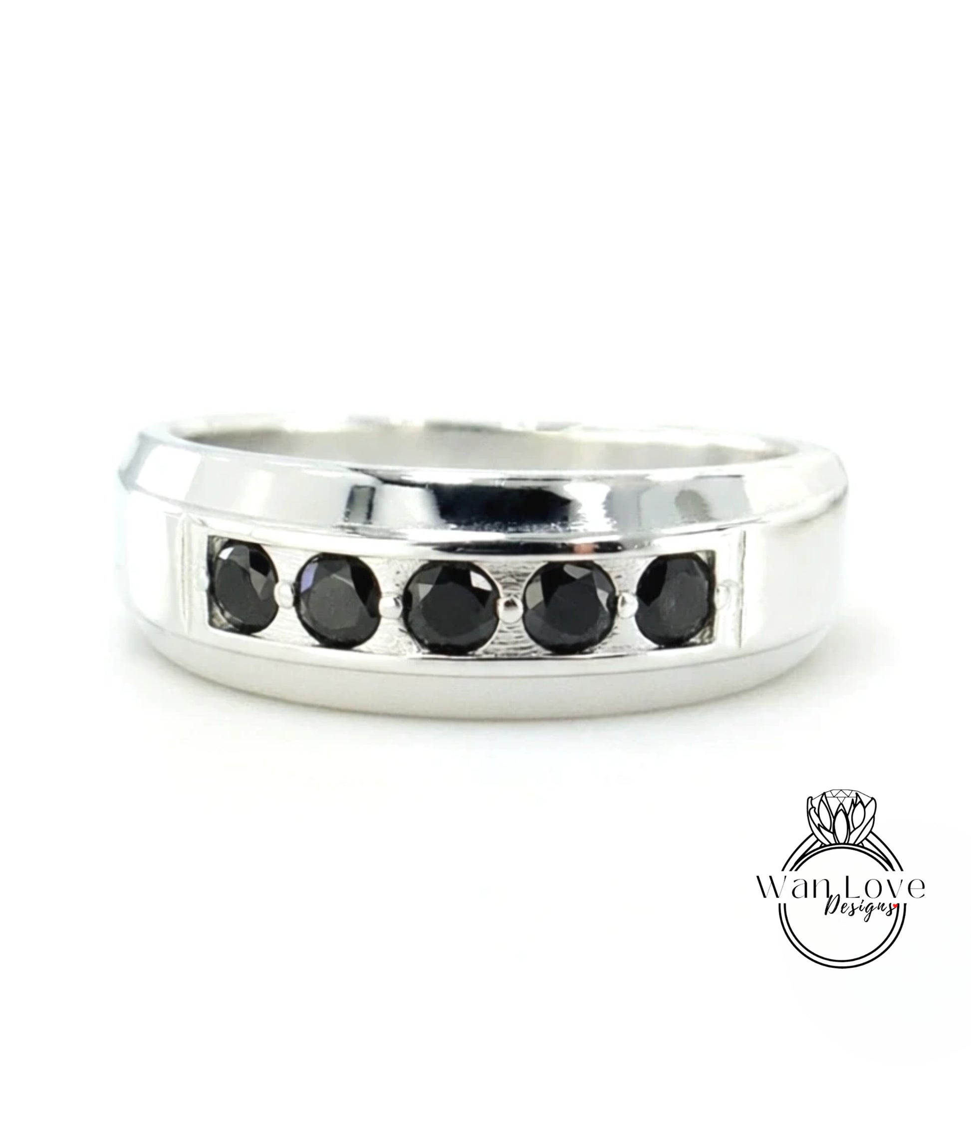 A silver ring with a row of black diamonds set in the band.
