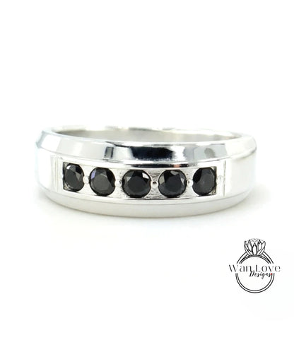 A silver ring with a row of black diamonds set in the band.