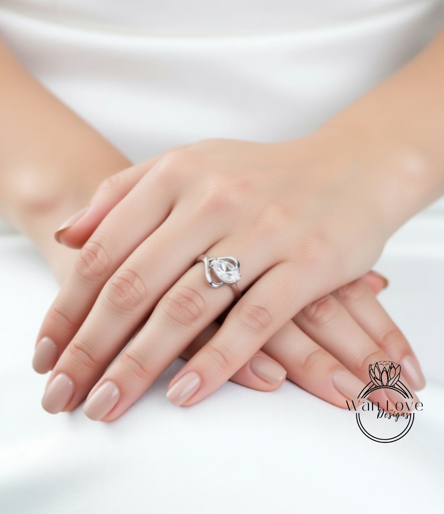 A close-up image of a person's hands wearing a diamond engagement ring.