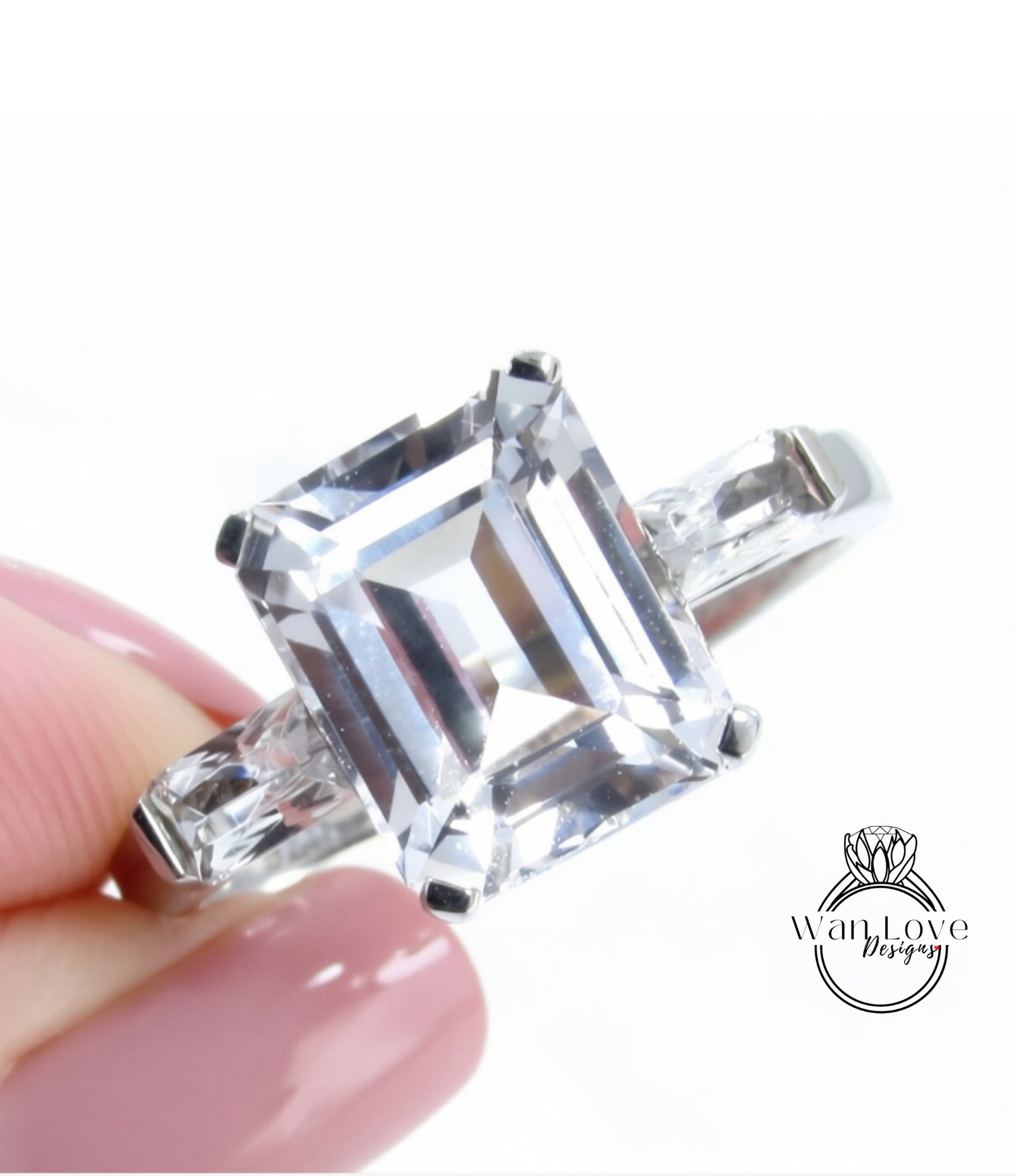 A close-up image of a person's hand holding a diamond engagement ring with a large, clear gemstone.