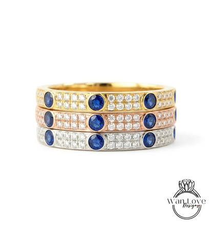 A stack of three rings with blue gemstones and diamonds set in gold and silver.