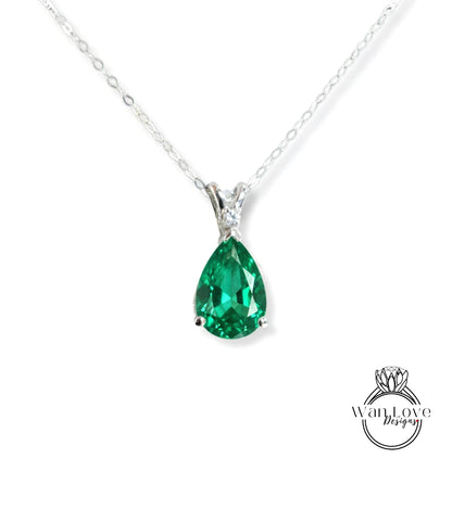 A silver necklace with a large, green gemstone pendant.