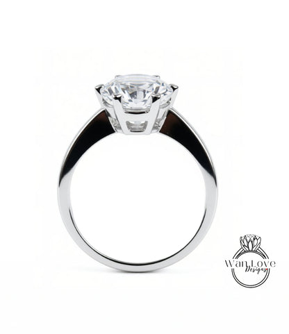 A close-up of a silver ring with a large, clear gemstone set in the center.