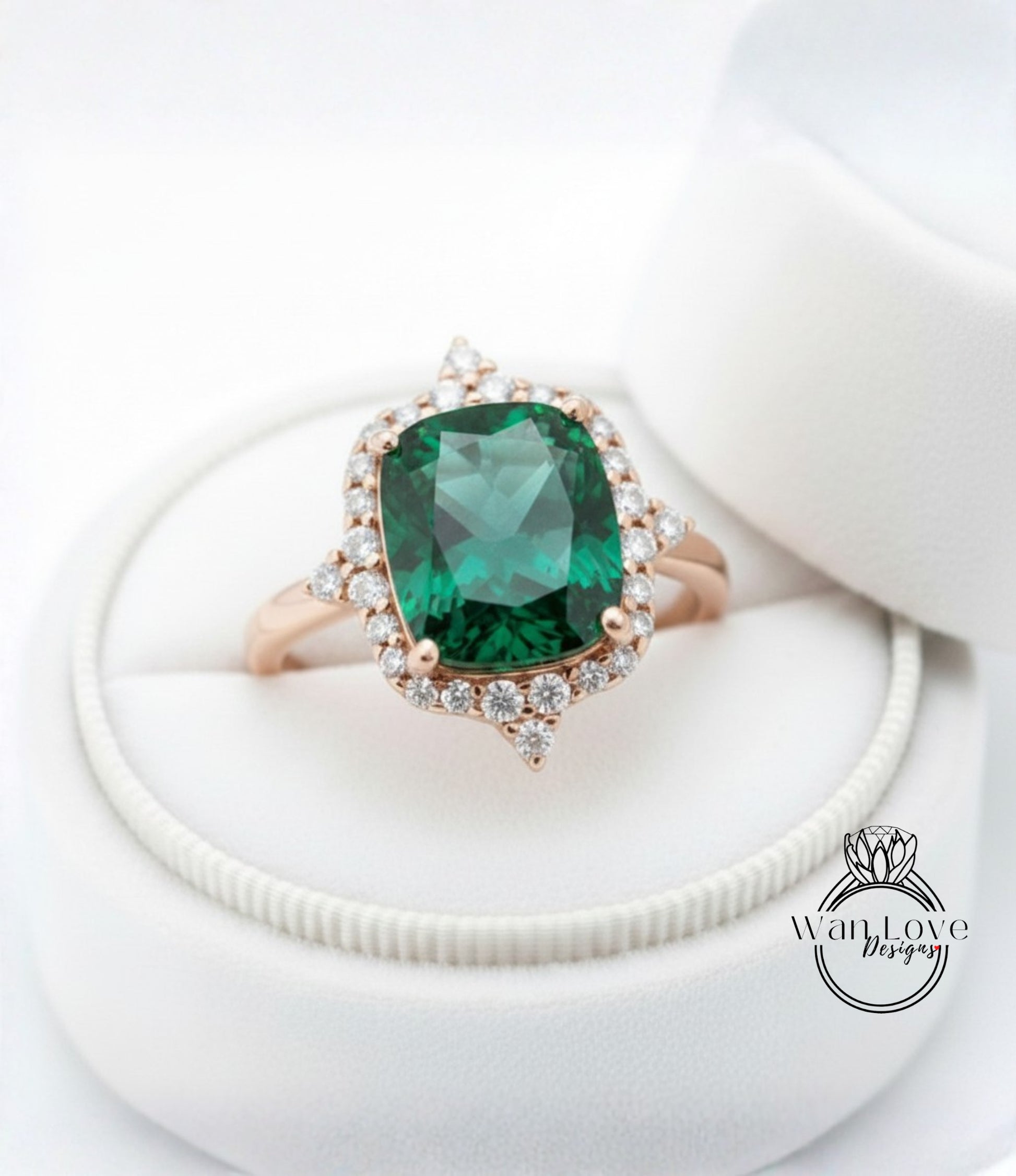 A close-up image of a gold ring with a large, green gemstone set in a halo of smaller diamonds, displayed in a white jewelry box.