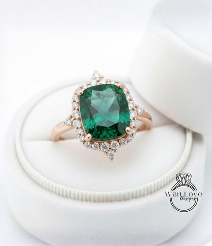 A close-up image of a gold ring with a large, green gemstone set in a halo of smaller diamonds, displayed in a white jewelry box.