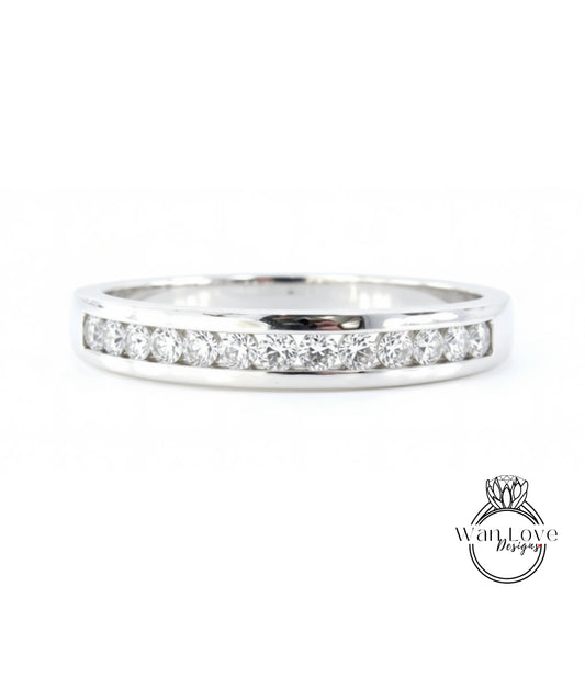 A silver ring with a row of diamonds set in it.