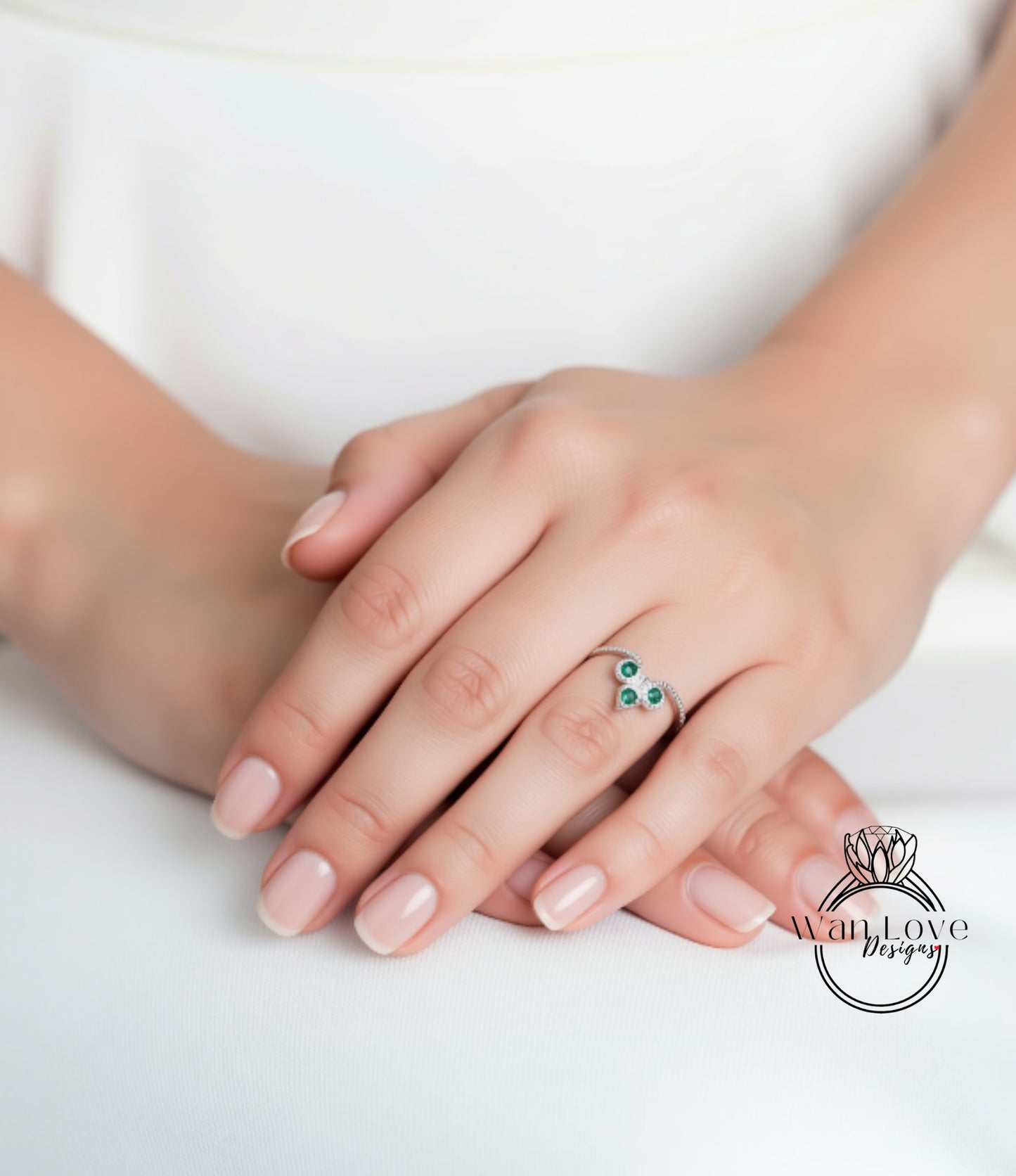 A close-up of a person's hand wearing a ring with a green gemstone.