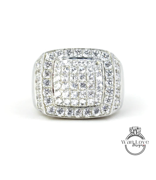 A silver ring with a large central diamond surrounded by smaller diamonds, showcasing a high-quality and luxurious design.