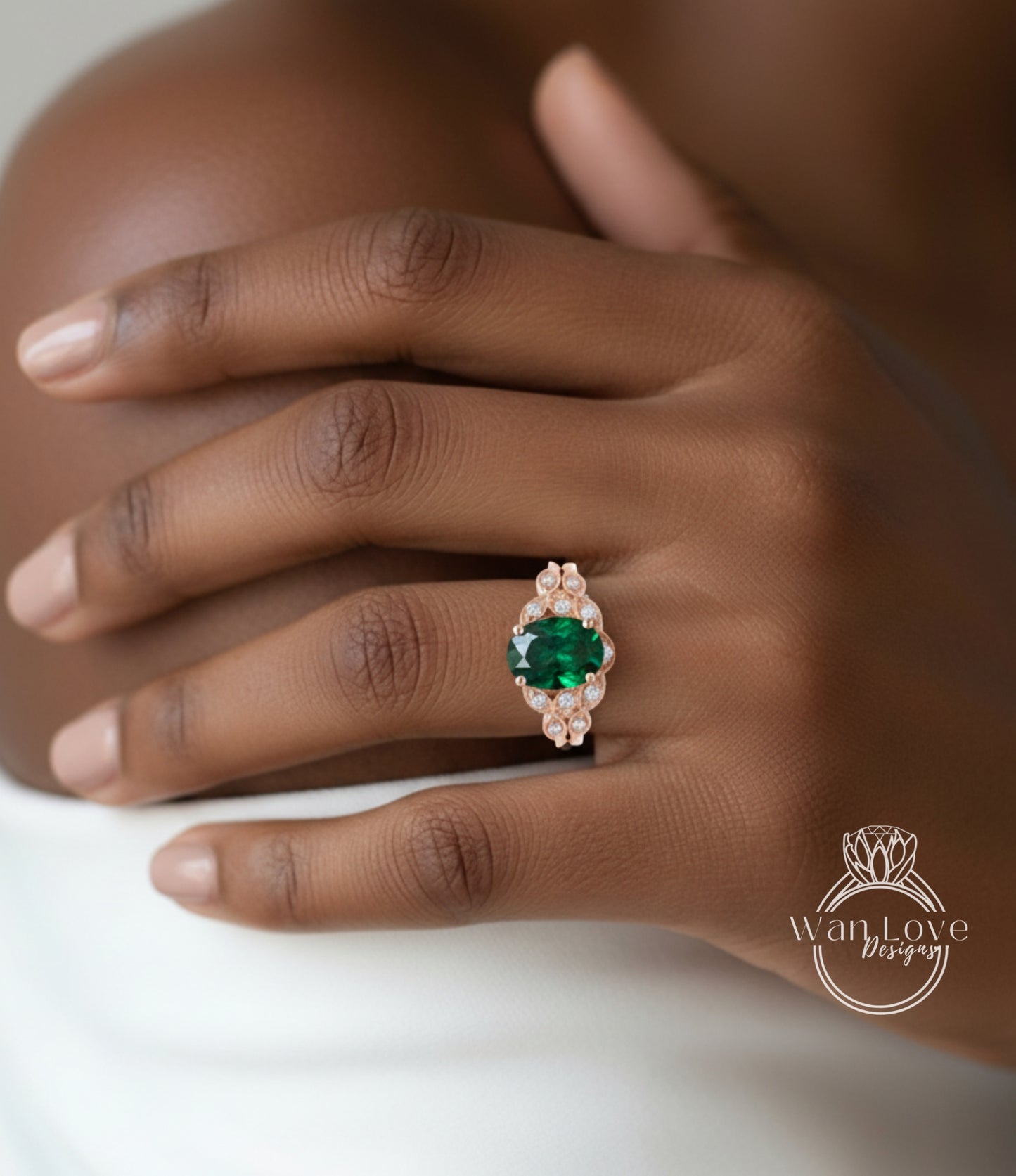 A close-up of a person's hand wearing a ring with a large, green gemstone surrounded by smaller stones.